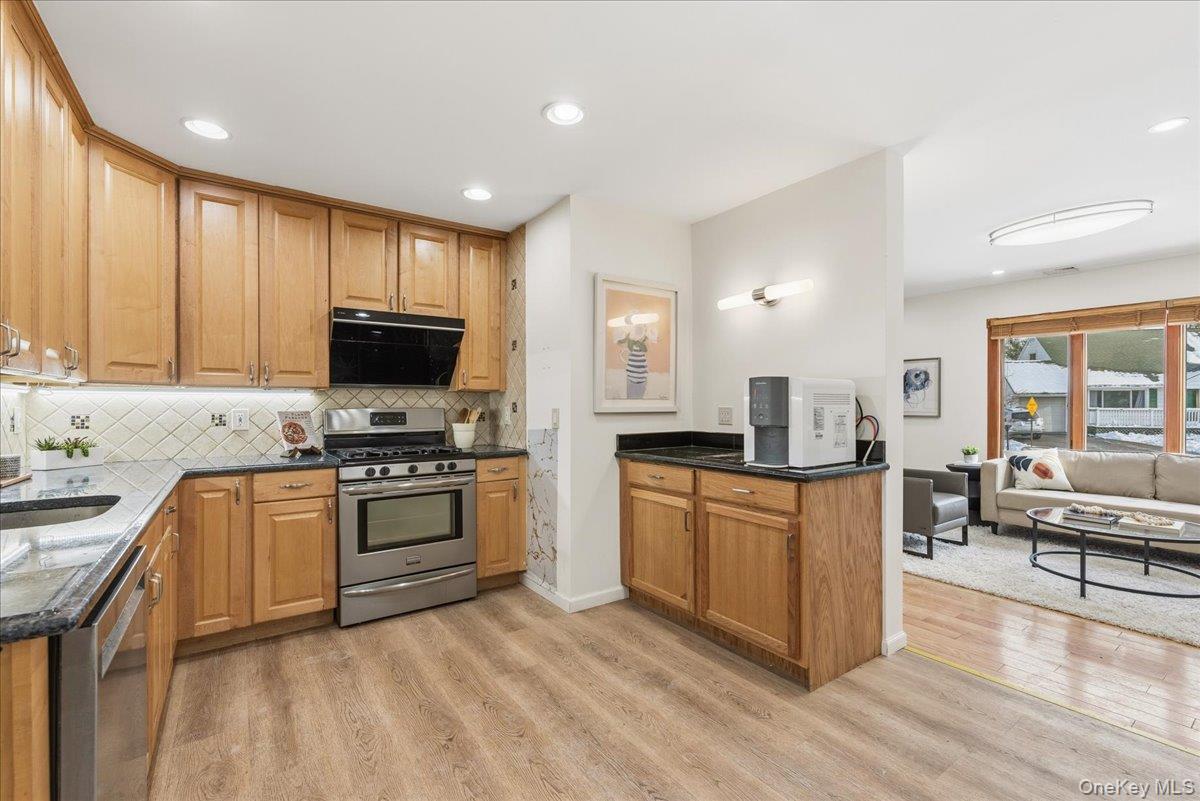 85 Briarcliff Road Westbury, NY 11590 - Photo 9 of 31 Kitchen with dark stone countertops, stainless steel appliances, light wood finished floors, tasteful backsplash, and recessed lighting