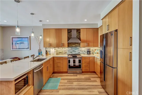 a kitchen with stainless steel appliances granite countertop a sink stove and refrigerator