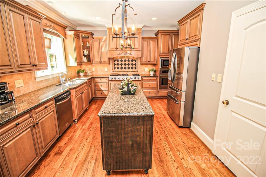 3239 Millstone Creek Road Lancaster, SC 29720 - Photo 18 of 48 a kitchen with stainless steel appliances granite countertop a refrigerator a sink dishwasher a stove and a dining table with wooden floor