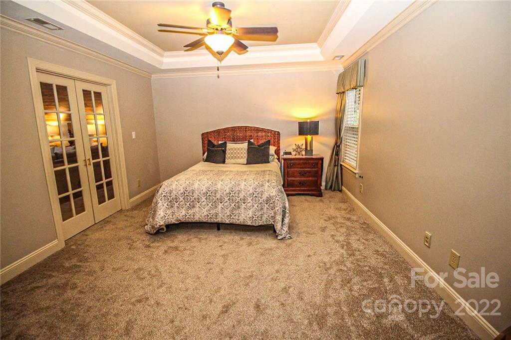 3239 Millstone Creek Road Lancaster, SC 29720 - Photo 35 of 48 a bedroom with a bed and a chandelier