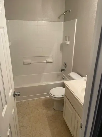 a view of an empty room with a fireplace and a window