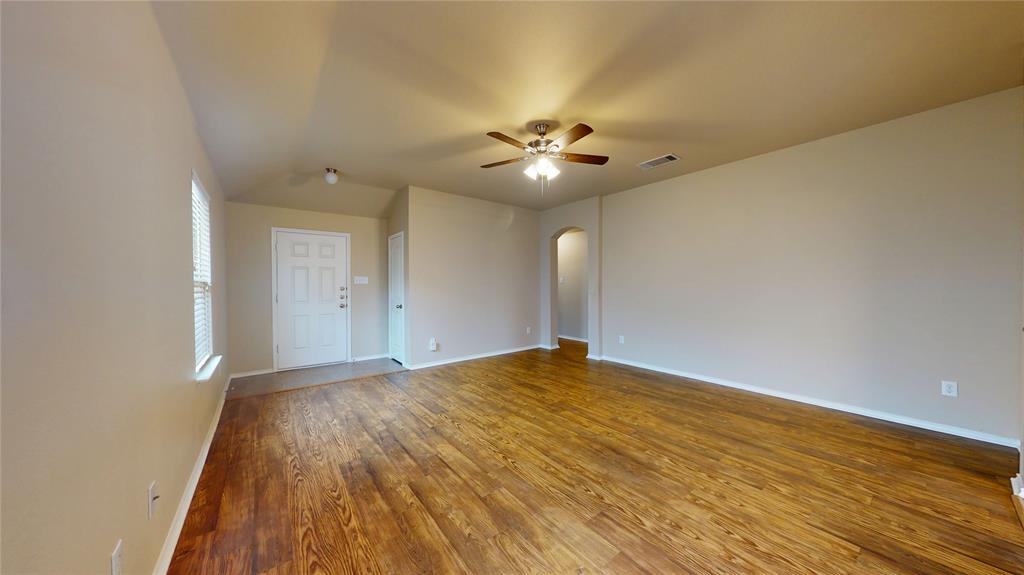 471 Harding Lane Lavon, TX 75166 - Photo 4 of 19 Empty room featuring arched walkways, dark wood-style flooring, a ceiling fan, and vaulted ceiling