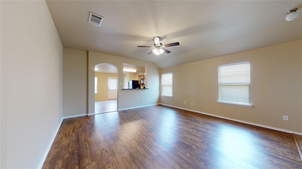 471 Harding Lane Lavon, TX 75166 - Photo 5 of 19 Unfurnished living room featuring a ceiling fan, dark wood finished floors, arched walkways, and lofted ceiling
