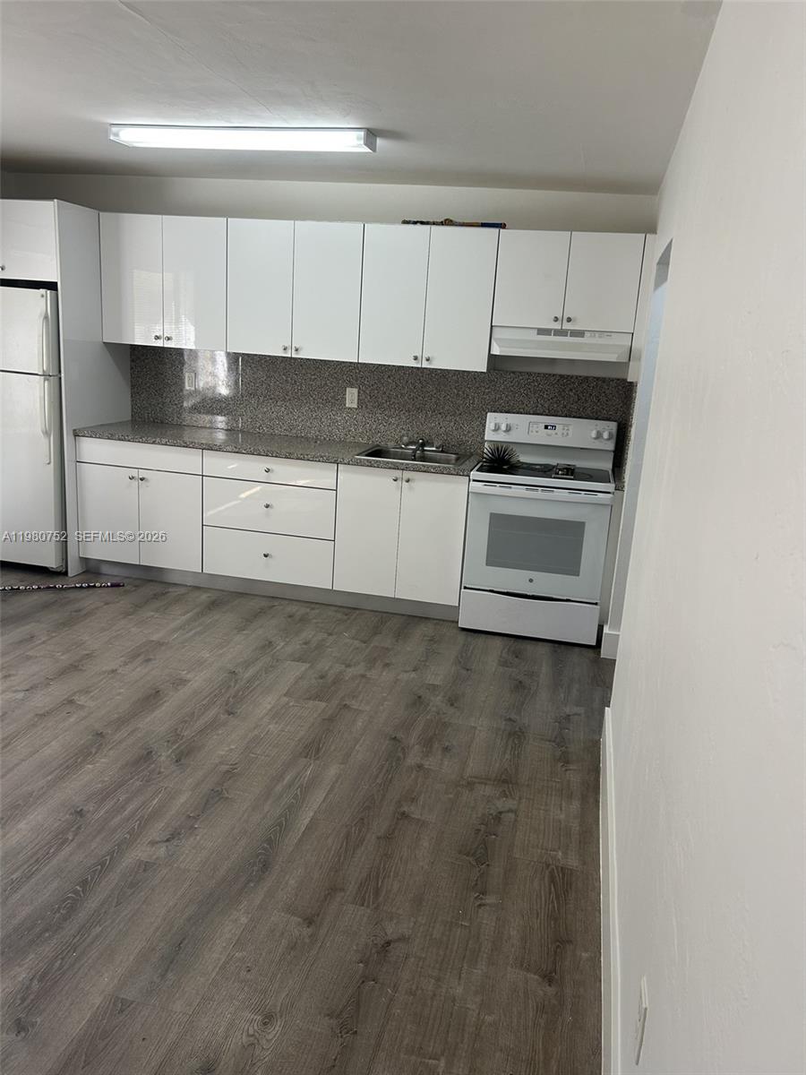 34 West 31st Street, Unit 4 Hialeah, FL 33012 - Photo 11 of 14 a kitchen with granite countertop white cabinets and stainless steel appliances