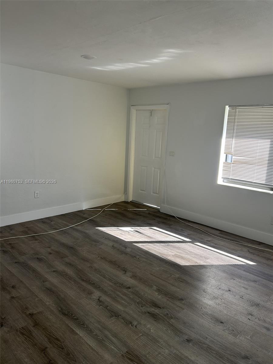 34 West 31st Street, Unit 4 Hialeah, FL 33012 - Photo 9 of 14 an empty room with wooden floor and windows