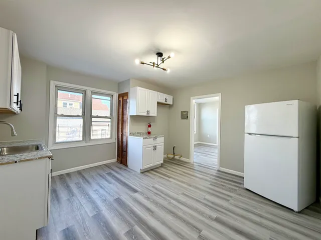 a view of a kitchen with a refrigerator and a stove top oven