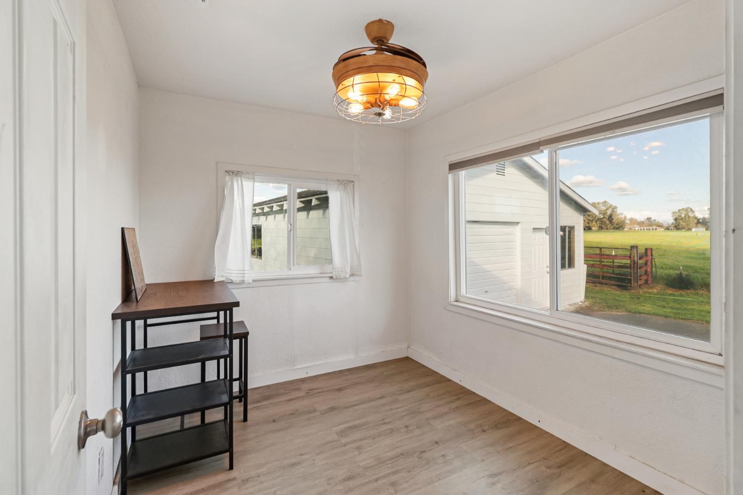 10695 Calvine Road Sacramento, CA 95830 - Photo 14 of 26 an empty room with windows and wooden floor