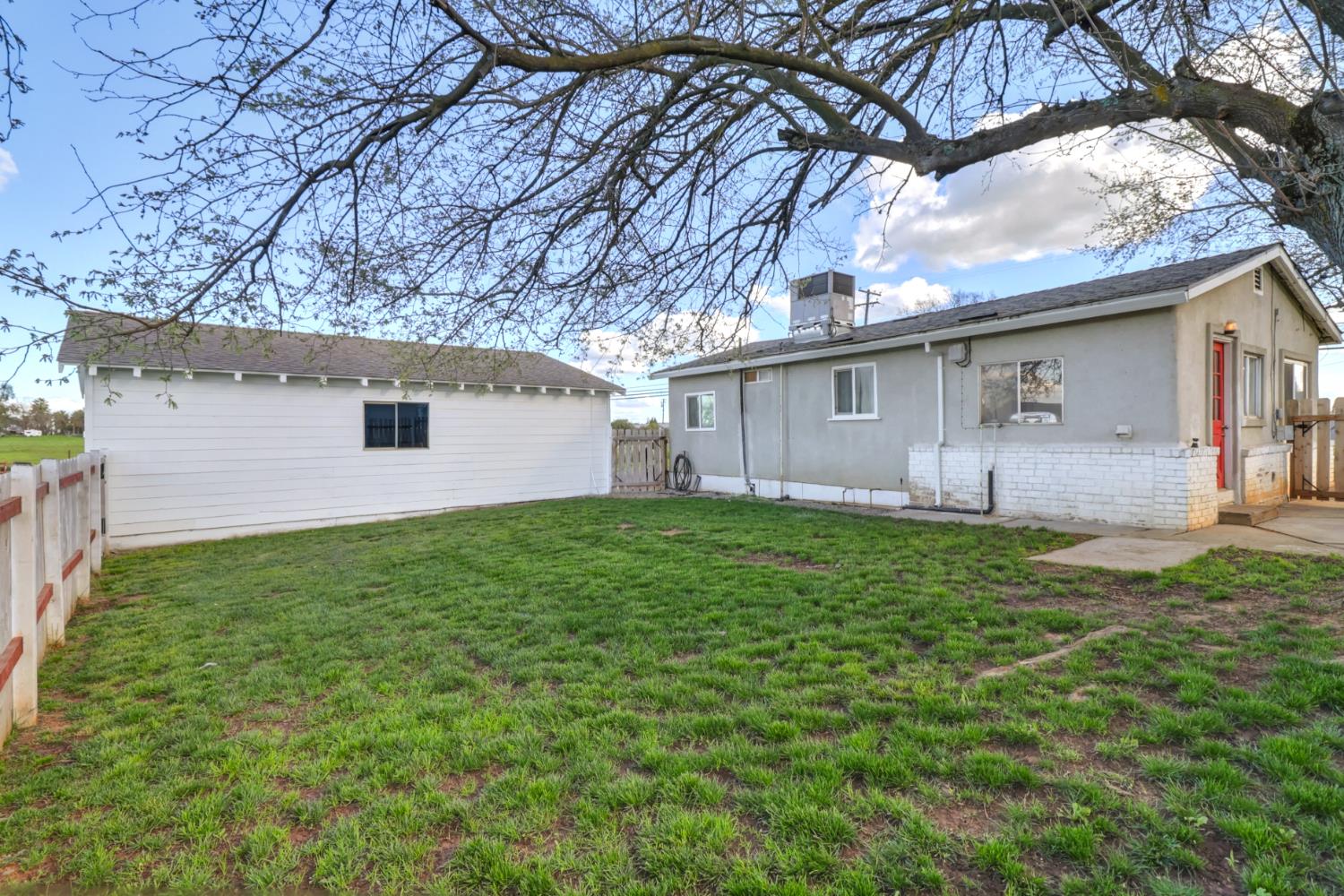 10695 Calvine Road Sacramento, CA 95830 - Photo 17 of 26 a backyard of a house with table and chairs under an umbrella