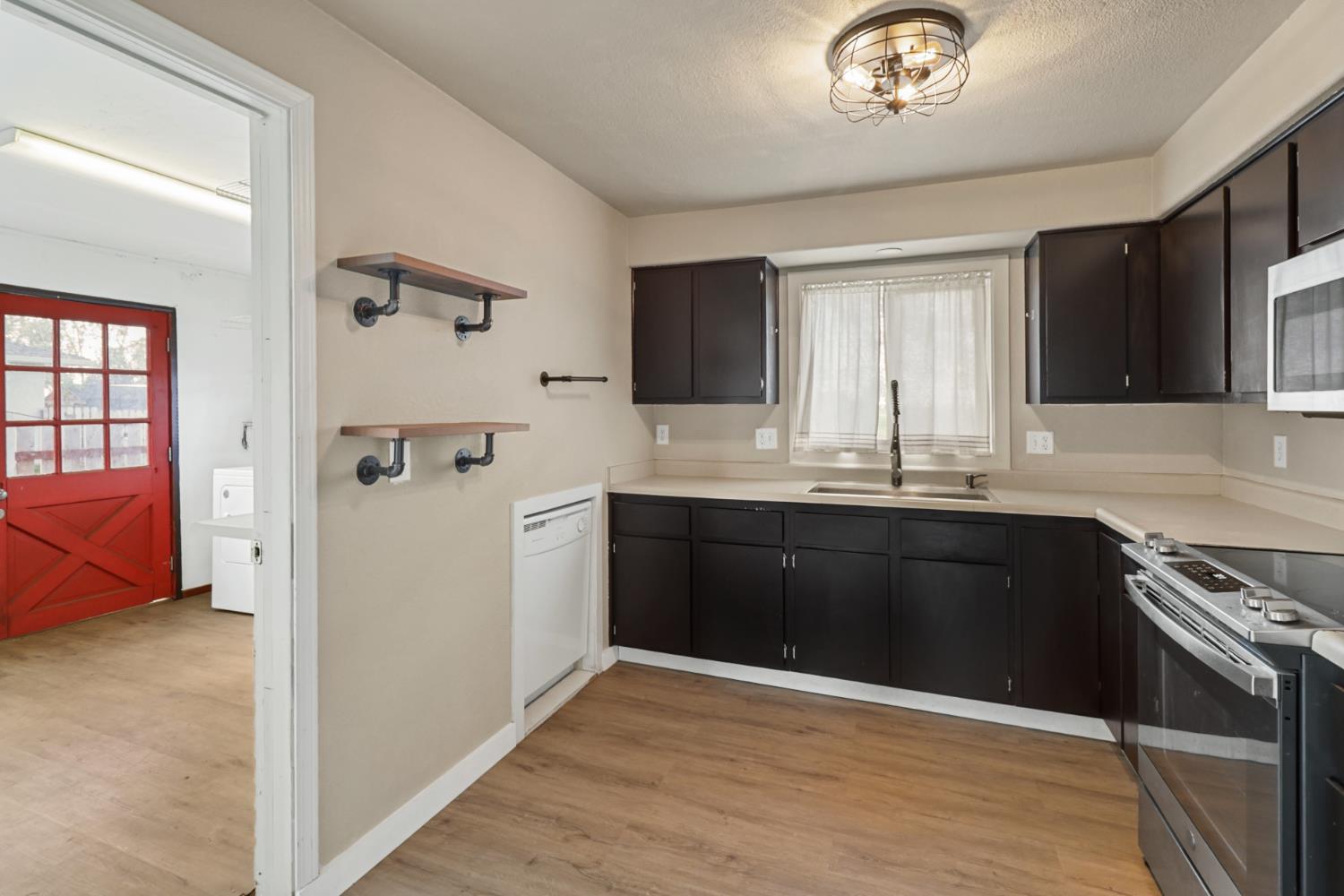 10695 Calvine Road Sacramento, CA 95830 - Photo 9 of 26 a kitchen with a stove a sink and a refrigerator