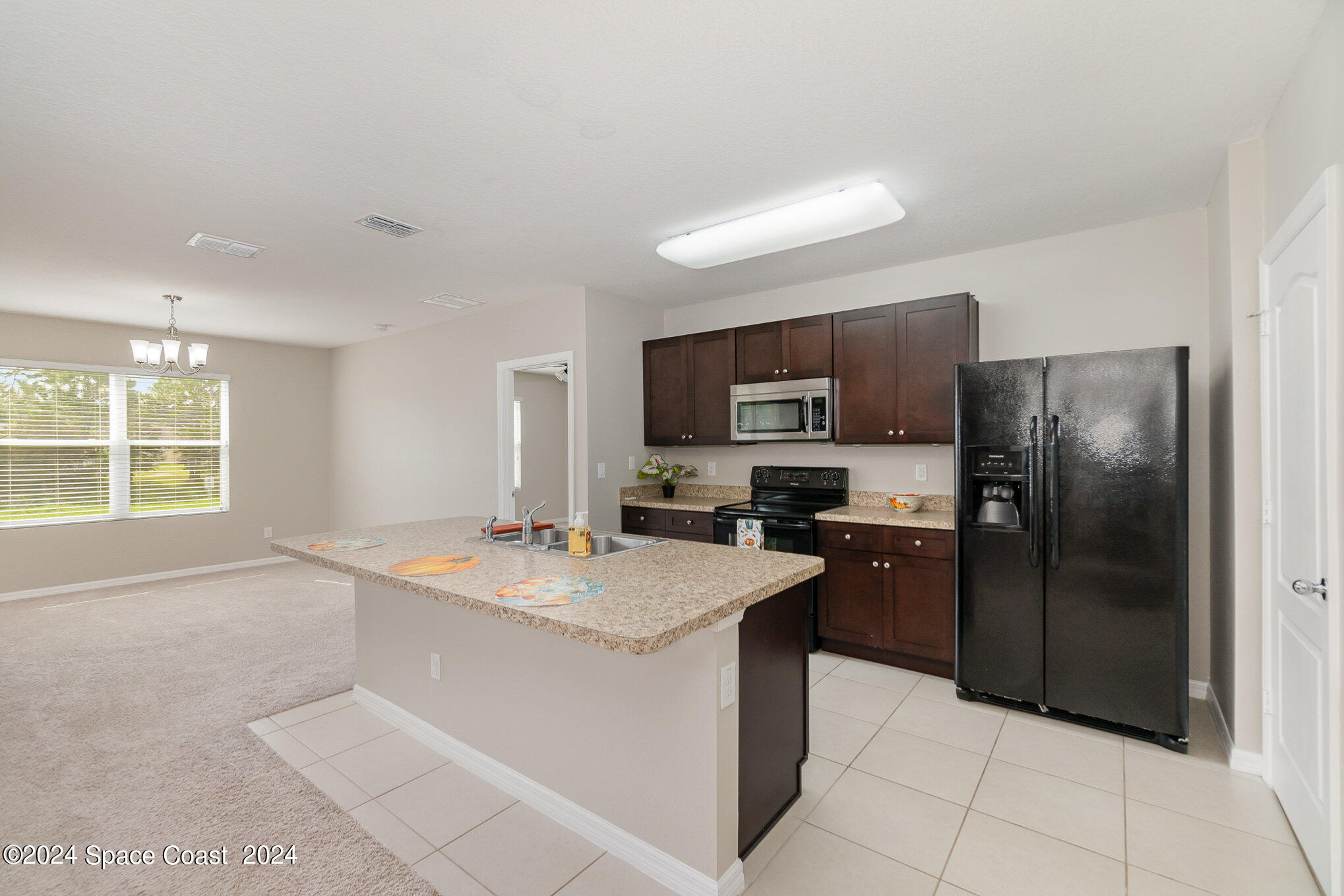 5305 Bear Corn Run Port Orange, FL 32128 - Photo 11 of 33 a kitchen with a refrigerator sink and microwave