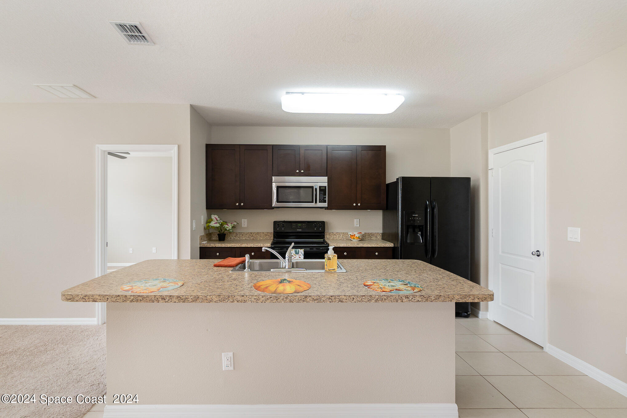 5305 Bear Corn Run Port Orange, FL 32128 - Photo 12 of 33 a kitchen with stainless steel appliances granite countertop a sink stove and refrigerator