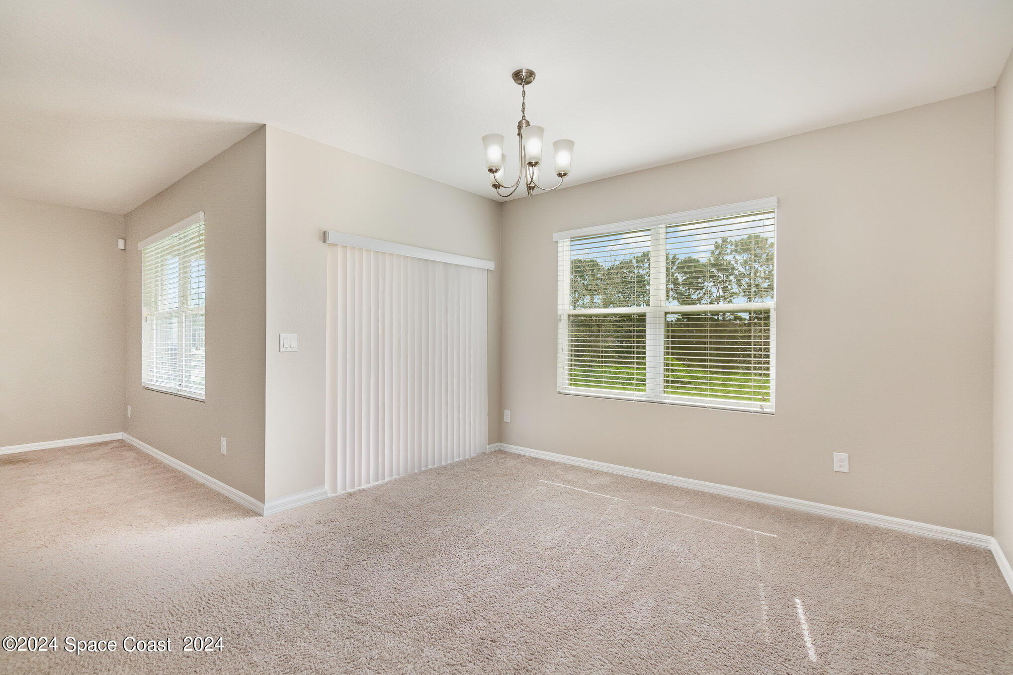5305 Bear Corn Run Port Orange, FL 32128 - Photo 8 of 33 an empty room with windows and chandelier