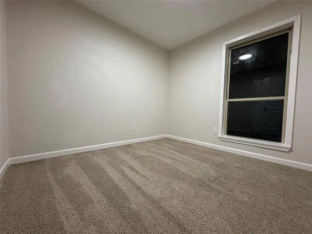 a view of an empty room with a fireplace and a window