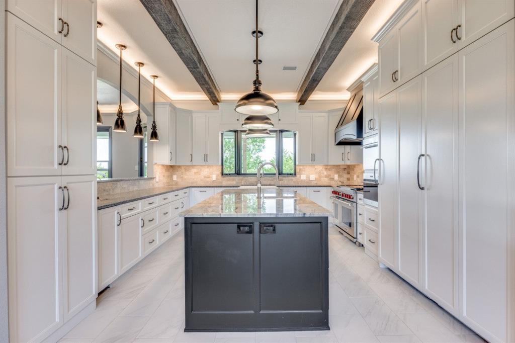 3244 Joe Davis Road Whitewright, TX 75491 - Photo 6 of 28 Kitchen with beam ceiling, a center island with sink, range with two ovens, hanging light fixtures, and light marble finish floors