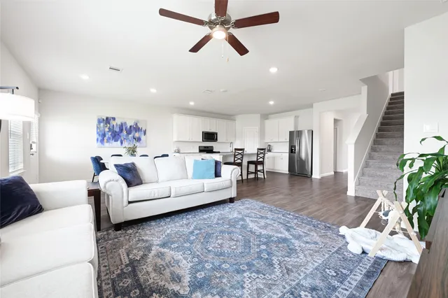a living room with furniture and a view of kitchen