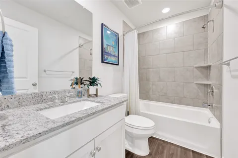 a bathroom with a granite countertop sink toilet and shower