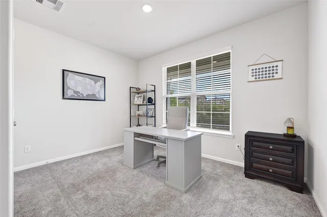 a view of a workspace with furniture and a window