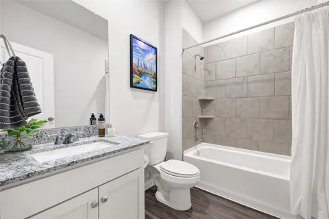 a bathroom with a granite countertop sink a toilet and a bathtub