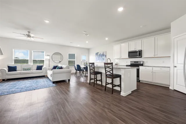 a living room with furniture and a wooden floor