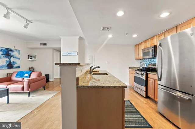 a kitchen with stainless steel appliances granite countertop refrigerator sink and stove
