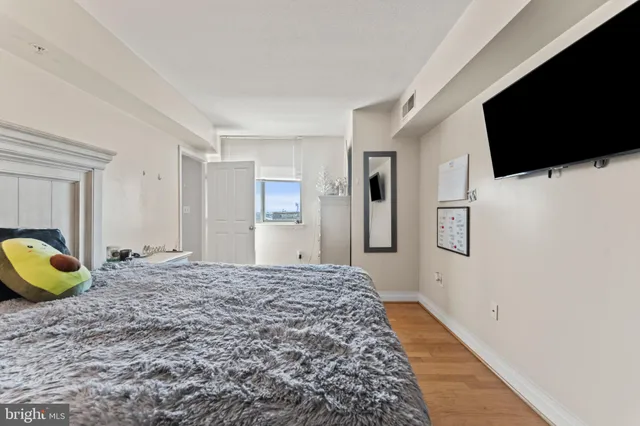 a spacious bedroom with a bed and a flat screen tv