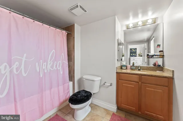 a spacious bathroom with a toilet sink and mirror