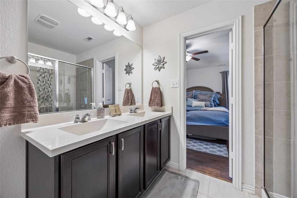 406 Madrone Lane Princeton, TX 75407 - Photo 16 of 30 Primary Bathroom vanity featuring dual sinks, white countertop, dark wood-finish cabinetry, and an expansive mirror with overhead lighting