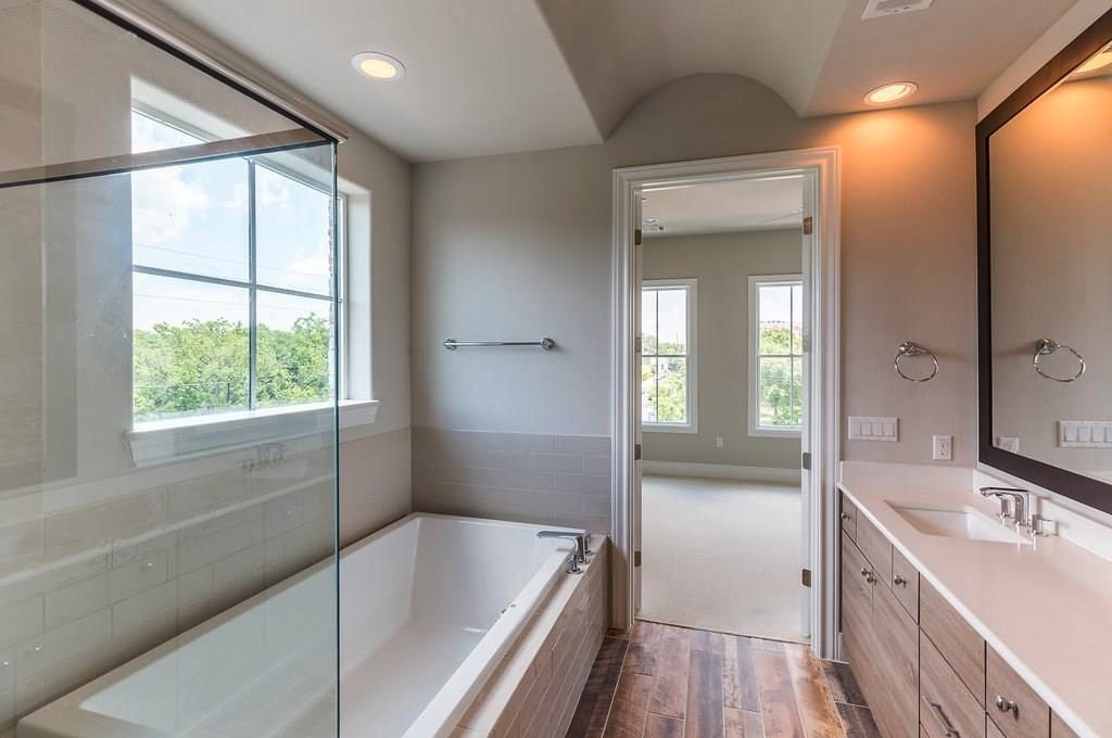 1312 Tinnin Ford Road Austin, TX 78741 - Photo 11 of 12 a bathroom with a tub a sink and a large mirror