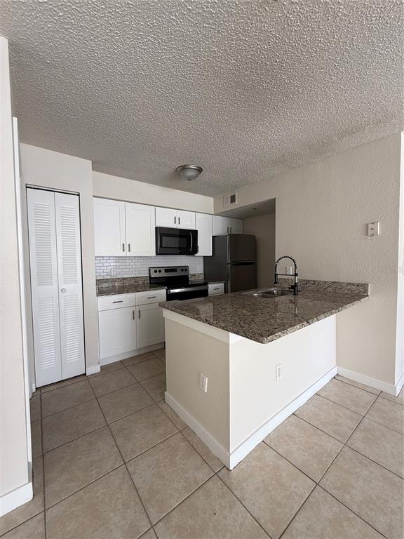 2201 Key W Court, Unit 314 Kissimmee, FL 34741 - Photo 12 of 58 a kitchen with stainless steel appliances granite countertop a sink and cabinets