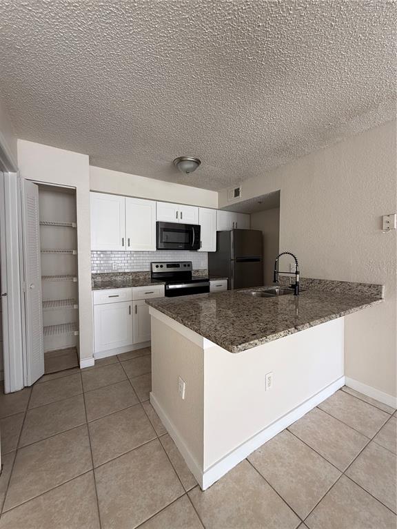 2201 Key W Court, Unit 314 Kissimmee, FL 34741 - Photo 13 of 58 a kitchen with stainless steel appliances granite countertop a sink and cabinets