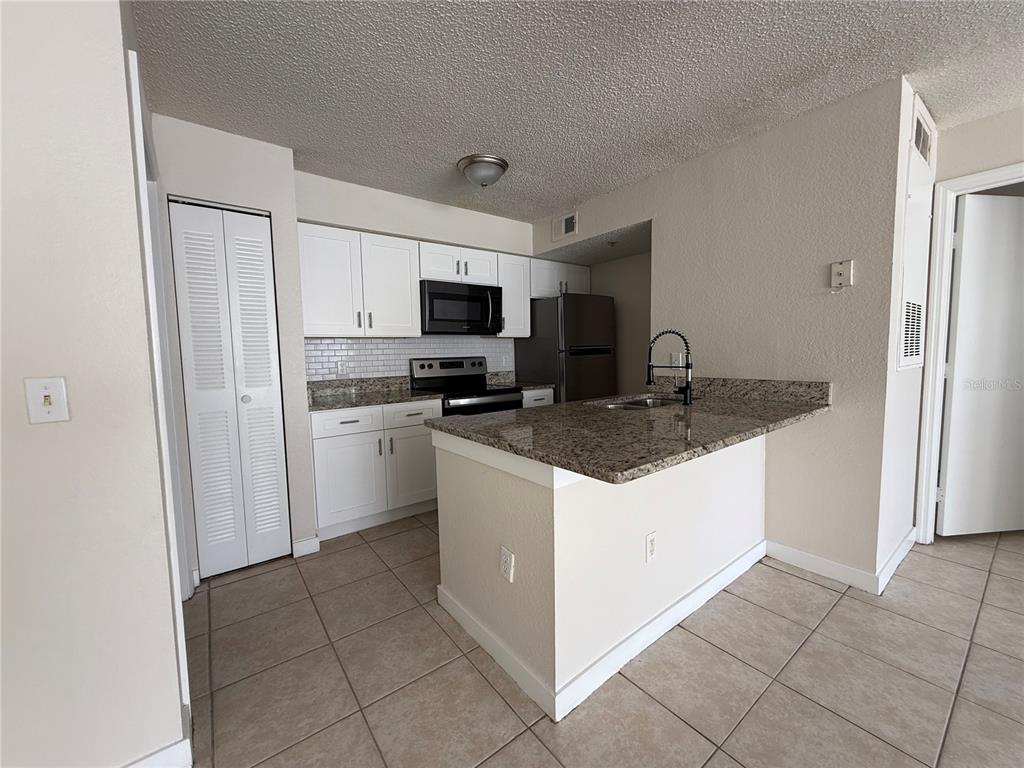 2201 Key W Court, Unit 314 Kissimmee, FL 34741 - Photo 14 of 58 a kitchen with stainless steel appliances granite countertop a sink stove and refrigerator