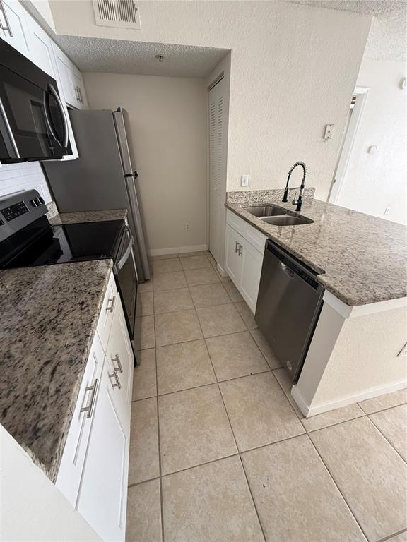 2201 Key W Court, Unit 314 Kissimmee, FL 34741 - Photo 15 of 58 a kitchen with a sink a stove and cabinets