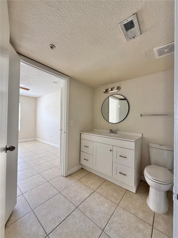 2201 Key W Court, Unit 314 Kissimmee, FL 34741 - Photo 45 of 58 a spacious bathroom with a granite countertop toilet a sink and a mirror