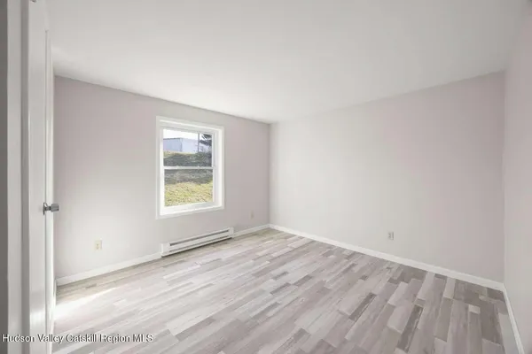 a view of a hallway with wooden cabinets and a refrigerator
