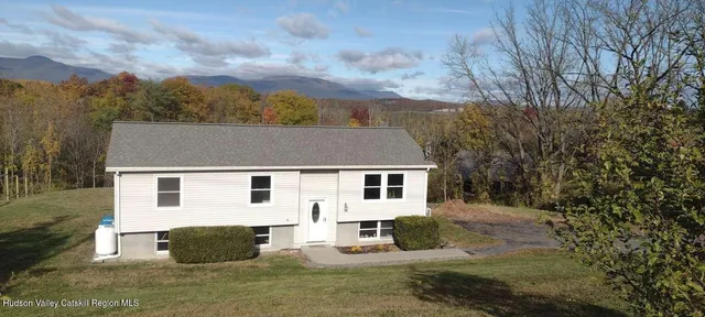 a view of a white house with a yard