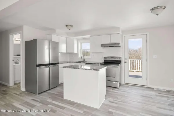 a kitchen with a refrigerator sink and cabinets