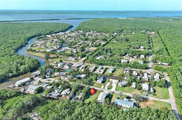an aerial view of residential houses with outdoor space and trees