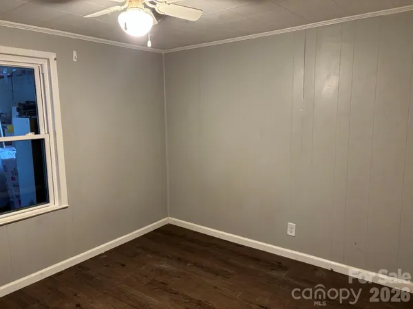 a view of an empty room with wooden floor