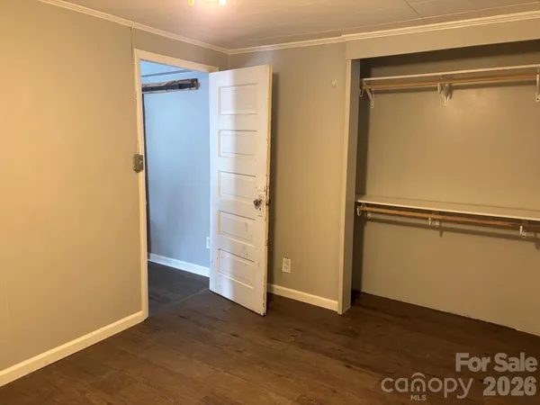 an empty room with wooden floor and closet