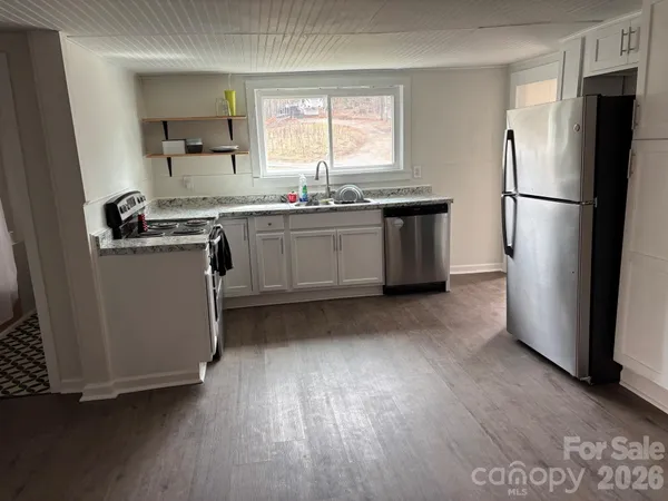 a kitchen with a refrigerator a sink and a stove top oven