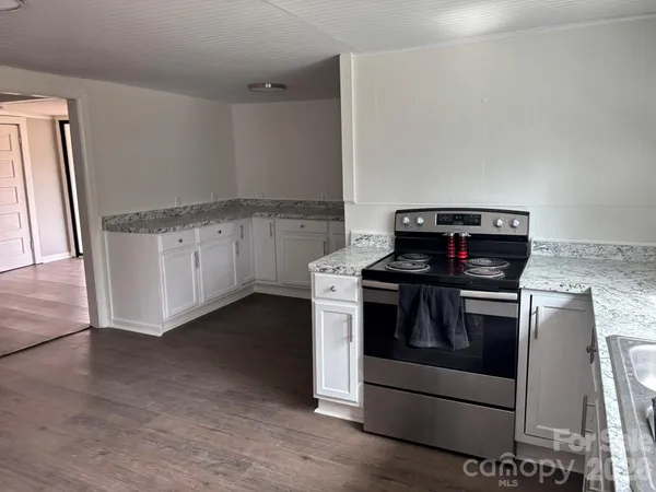 a kitchen with granite countertop white cabinets and white appliances