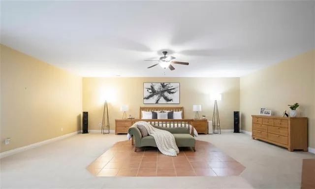 a bedroom with a large bed and a chandelier