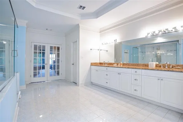 a spacious bathroom with a granite countertop double vanity sink mirror and