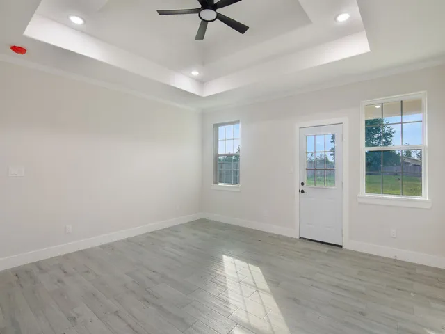 a view of a livingroom with a ceiling fan hardwood floor and a ceiling fan