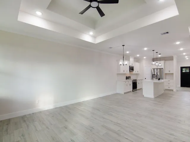 a living room with furniture kitchen view and a wooden floor