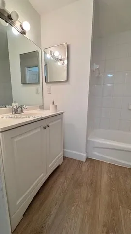 a bathroom with a double vanity sink mirror and bathtub