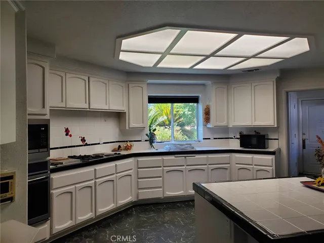 a kitchen with stainless steel appliances granite countertop a sink a stove and cabinets