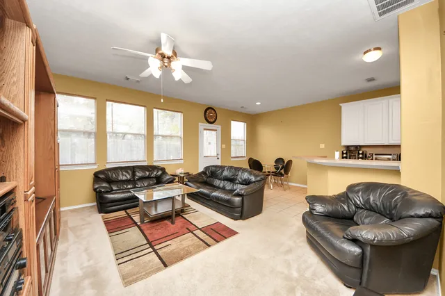 a living room with furniture a flat screen tv and a floor to ceiling window