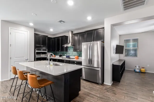 a kitchen with stainless steel appliances a refrigerator and a stove top oven