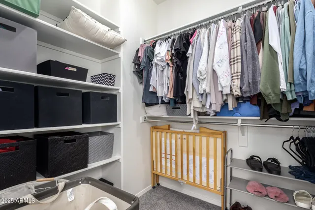 a view of walk in closet with clothes and shoes